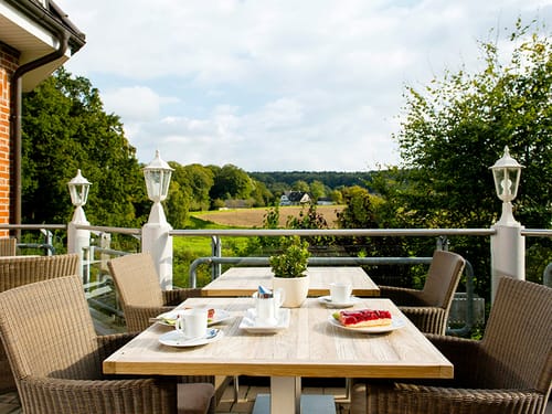Ein gedeckter Tisch auf der Hotelterrasse mit Blick über die Landschaft