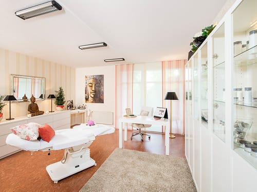 Heller Massagebereich mit einer Massageliege im Vordergrund