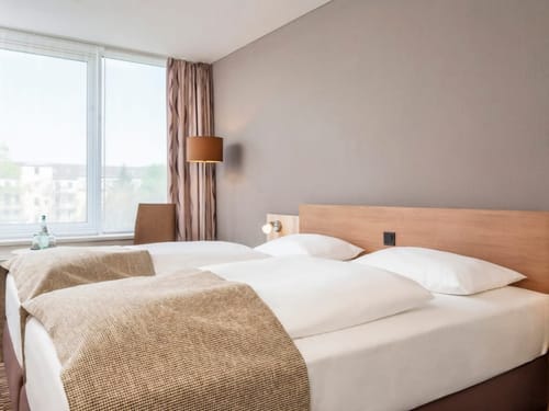 Helles Hotelzimmer mit Doppelbetten und zeitlosem Design