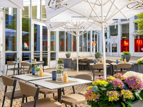 Restaurant Außenterrasse mit Sonnenschirmen und Blumendekoration