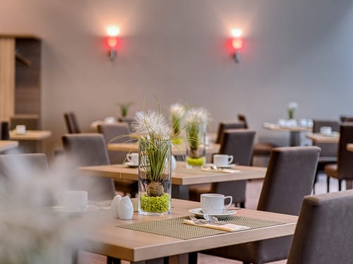 gedeckte Tische im Frühstücksraum