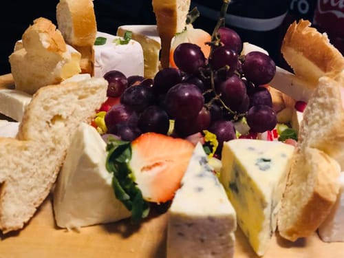 verschiedene Sorten Käse und dunkle Weintrauben