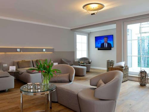 Wartebereich im Wellnessbereich mit Sesseln, Tisch und TV