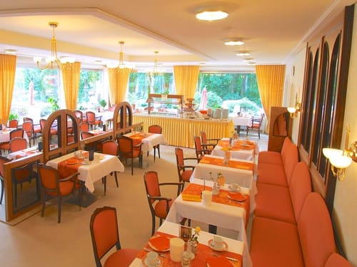 Hotelrestaurant mit weiß eingedeckten Tischen und Panoramafenstern