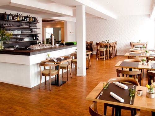 eingedeckte Tische und Bar im Restaurant