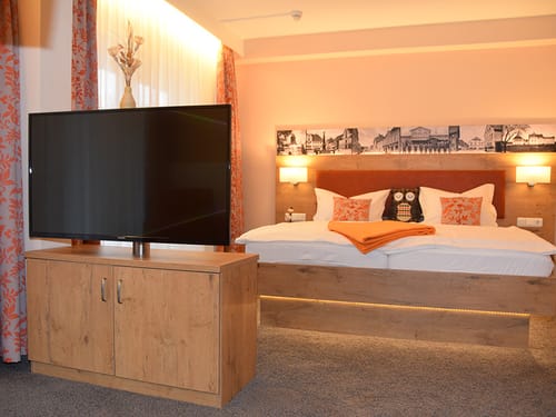 großes Doppelbett mit TV-Schrank und TV