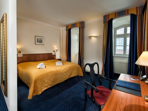 gemütöoches Doppelzimmer mit Doppelbett, Schreibtisch und Stuhl