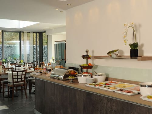 gedeckte Frühstückstische und eine vielfältige Auswahl am Buffet