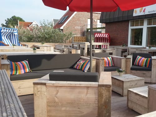 Gemütliche Terrasse mit loungemöbeln und bunt gestreiften Kissen