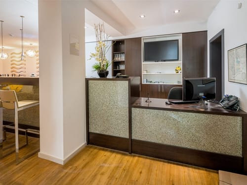 Entdecken Sie unseren modernen Empfangsbereich mit elegantem Holzfußboden und stilvollem Interieur. Perfekt für einen professionellen ersten Eindruck.