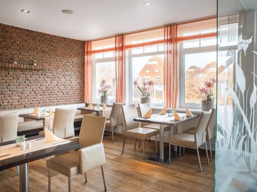 Gemütliches Restaurant mit moderner Einrichtung und Backsteinwand.