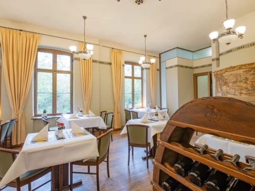Gemütliches Restaurantinterieur mit gedeckten Tischen und Weinregal
