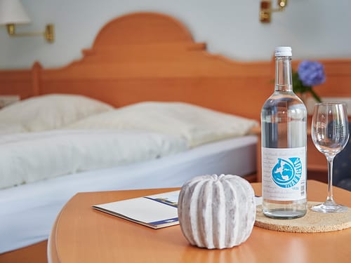 Doppelzimmer mit einer Flasche Wasser und Glas auf dem Tisch