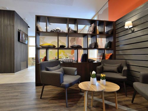 modern und offen gestaltete Bar mit Sesseln und Raumteiler