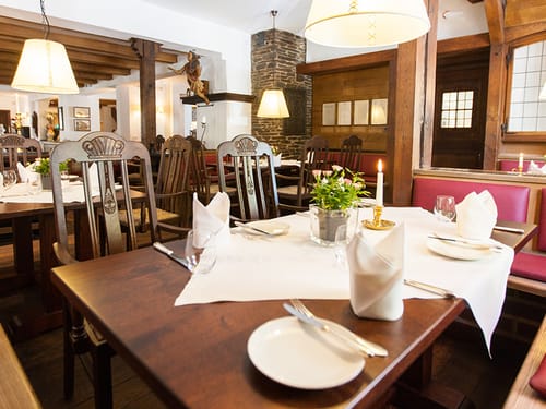 eingedecke Tische mit weißen Servietten und Tischdecken
