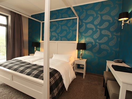 Standardzimmer Doppelzimmer mit Himmelbett, Nachttisch, Stehlampen und Sideboard