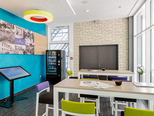 Aufenthaltsbereich in der Lobby mit Snackautomat und Sitzgelegenheiten