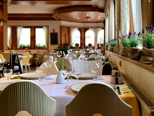 Hotel Restaurant mit eingedeckten Tischen und Lavendel vor den Fenstern