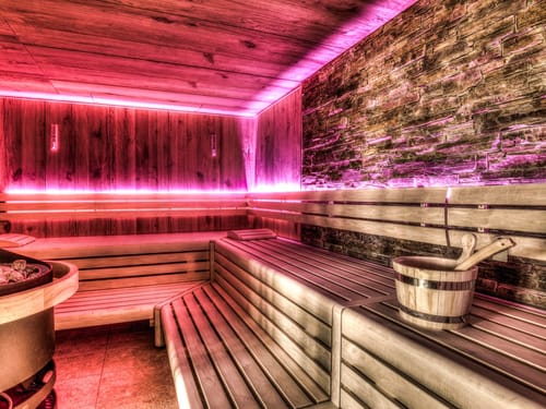 Moderne Sauna mit stimmungsvoller Beleuchtung und hölzernem Interieur