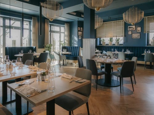Modernes Restaurantinterieur mit stilvoller Einrichtung und gedeckten Tischen.