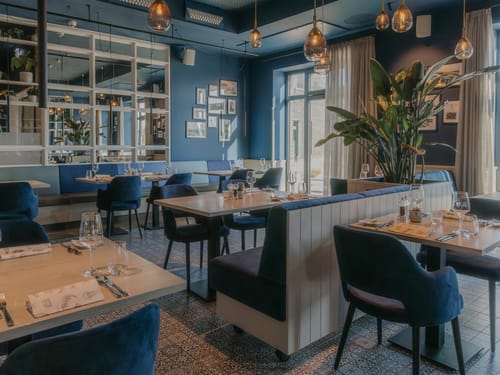 Stilvolles Restaurantinterieur mit blauen Wänden und eleganten Möbeln