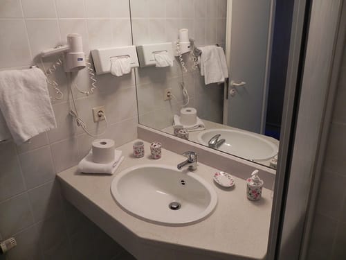 Badbereich mit Waschtisch, Föhn und Wandspiegel