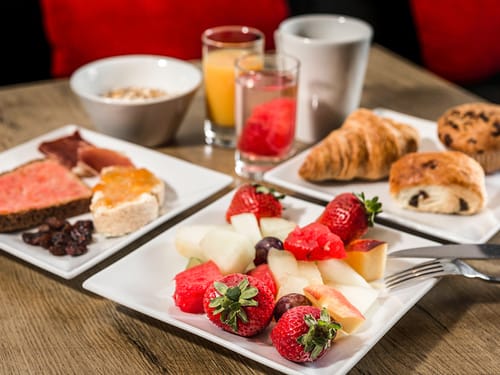 gedeckter Tisch mit Backwaren, Saft und frischem Obst