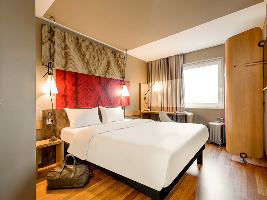 modernes Doppelzimmer mit Boxspingbett, Schreibtisch, TV und Schrankwand