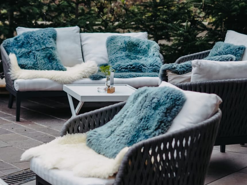 Gemütliche Outdoor-Lounge mit blauen und weißen Kissen und Decken.