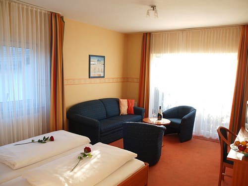 Sitzbereich im Doppelzimmer mit Couch, Sessel und Tisch
