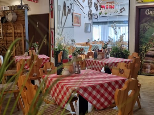 kleine Tischnischen, Theke und viel Deko unter der Decke in der Gaststube