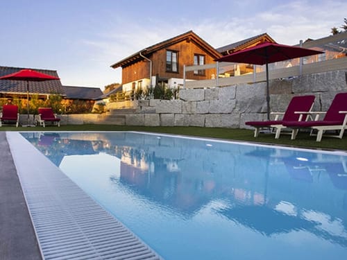 Pool im Aussenbereich mit Liegen und Sonnenschirmen