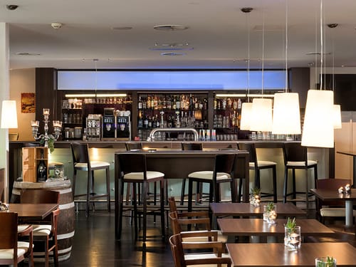 Hotelbar mit Barhockern, Stehtisch sowie Tische und Stühle