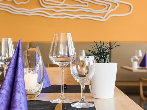 eingedeckter Tisch im Restaurant mit Wasser und Weinglas