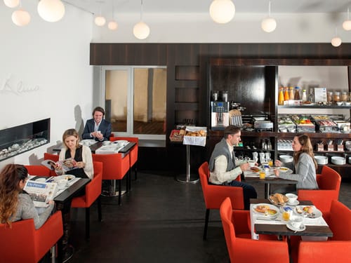 einige Gäste sitzend am Tisch während des Frühstücks