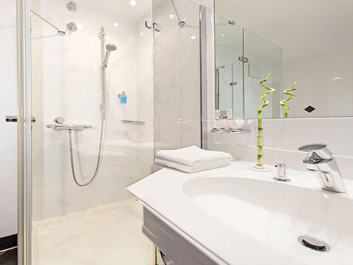 großer Wandspiegel, Waschtisch und Dusche