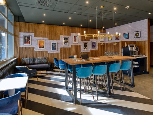 Moderne Lounge mit Holzelementen und blauen Barhockern