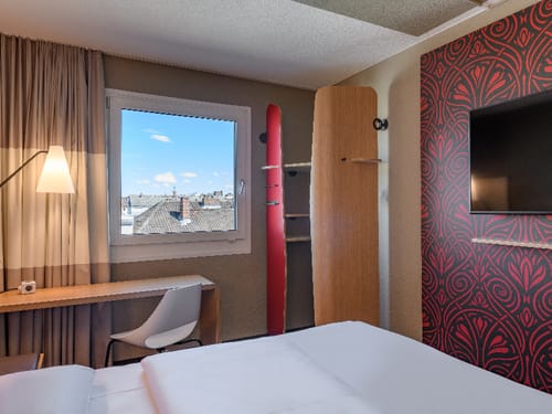 Modernes Hotelzimmer mit stilvollem Dekor, Schreibtisch und großem Fenster mit Aussicht.