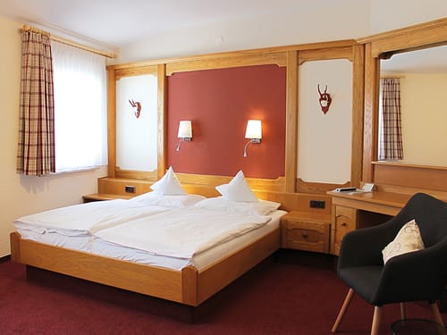 Standard Zimmer mit Doppelbett, Ablage und Sessel
