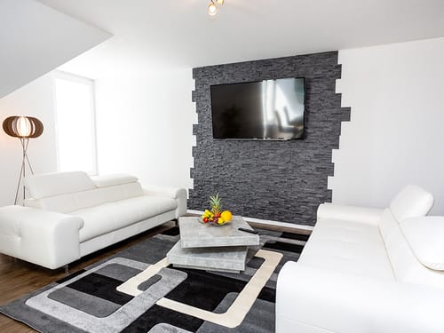 weiße Couch mit Marmortisch und TV