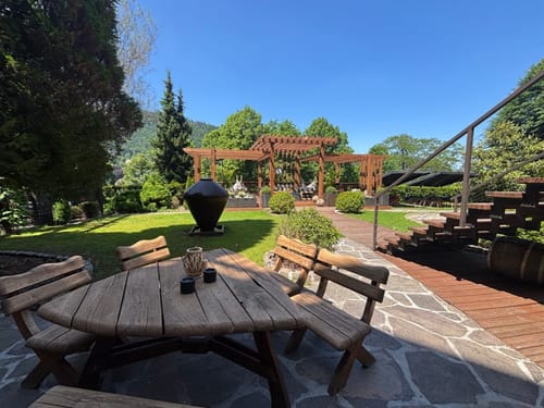 Wunderschöner Garten mit Holzpergola und rustikalen Gartenmöbeln