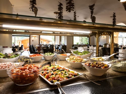 Entdecken Sie ein vielfältiges Buffet mit frischen Salaten und Beilagen in einem eleganten Restaurantambiente. Genießen Sie gesunde und schmackhafte Optionen in einem einladenden Speisesaal.