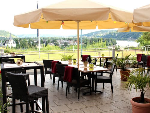 Hotel Terrasse mit Gartenmöbeln und Sonnenschirmen