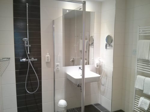 Bad mit Dusche, Wandspiegel, Kosmetikspiegel und Waschtisch