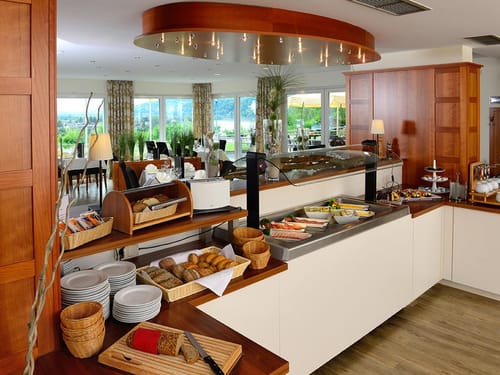 Frühstücksbuffet mit Brot, Brötchen, Obst und einer Wurst und Käseauswahl