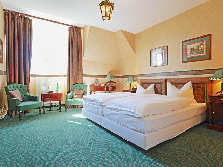 Standard Doppelzimmer mit einem Twinbett, Sesseln, Tisch, Stuhl und Schreibtisch