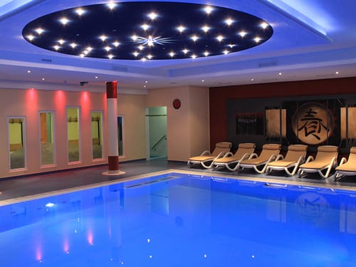 Indoor Pool mit Relaxliegen am Rande
