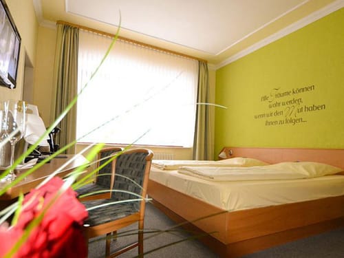Standard Zimmer mit Doppelbett, Stühlen, Schreibtisch und TV