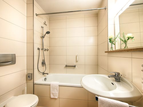 Badewanne, WC, Waschtisch und Wandspiegel im Bad