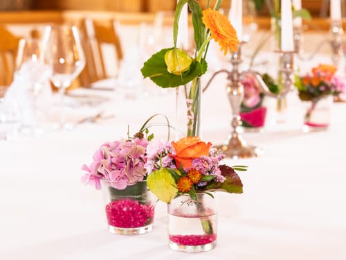 Gedeckter Tisch mit Blumenvasen